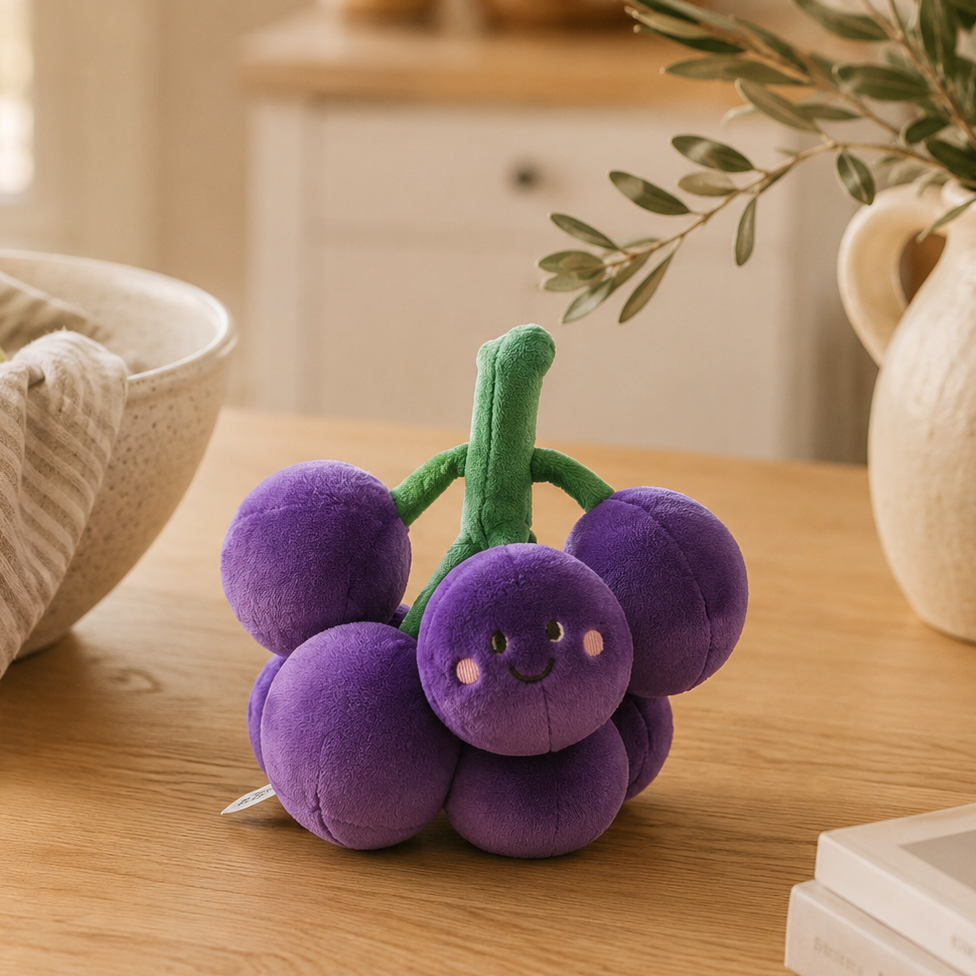 Grape Besitos plush toy displayed on an oak kitchen table in a warm Scandinavian-inspired home with soft natural décor Plushies South Africa