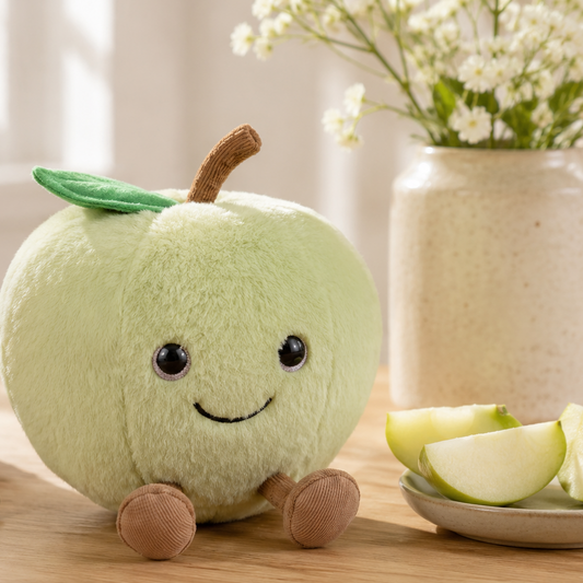 Green Apple Besitos plush toy displayed on an oak kitchen table beside fresh green apples in a bright Scandinavian-inspired kitchen Plushies South Africa
